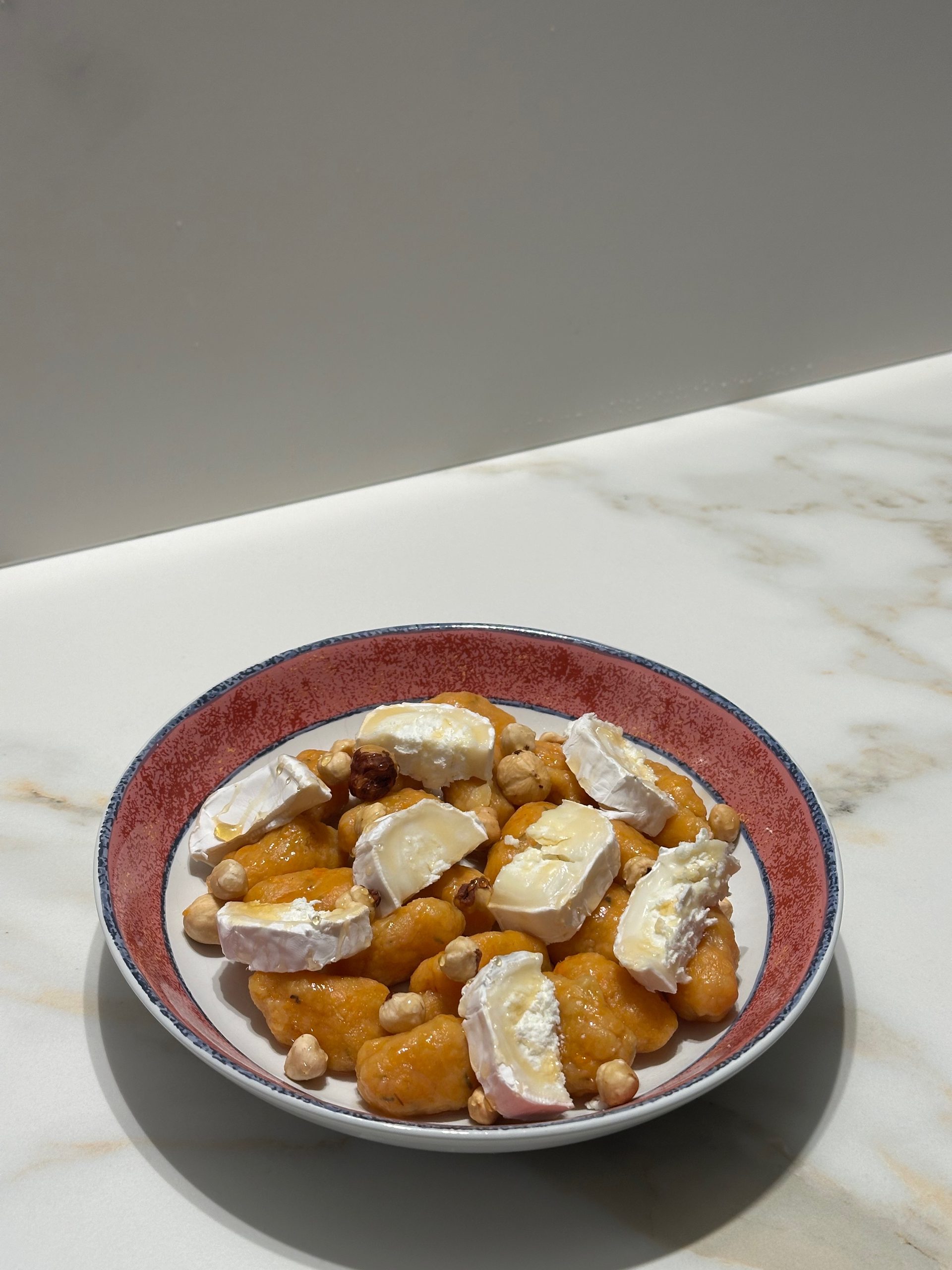 assiette de gnocchis maison faits à base de patate douce avec chèvre et miel